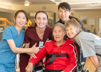 a resident with rehab therapists in the rehab gym at Los Altos Sub-acute