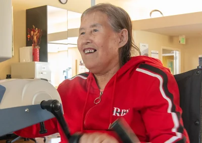 a resident in the rehab gym using a hand peddle machine